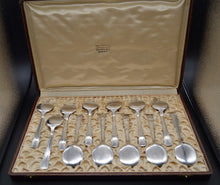 Charger l'image dans la galerie, 12 cuillères à glace en métal argenté dans leur coffret . Le tissu du coffret est jaune pâle,  plissé afin de ne pas voir les encoches qui calent les cuillères. sur le couvercle on peut lire : Henri Perier Place Belle croix Nîmes. Le tissu est en très bon état sans tâche et sans déchirures. La finition est faite d'une cordelette de couleur assortie au tissu.