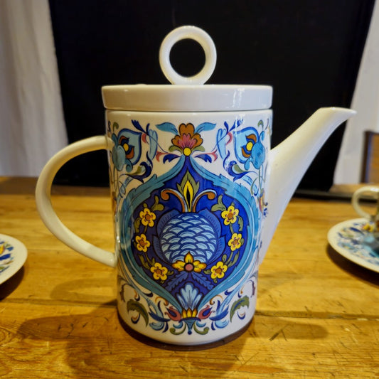 Cafetière (ou théière) colorées bleue jaune et brique. les différents tons de bleus et la symétrie des motifs donnent un coté oriental au décor.
un couvercle dont l'anse est en forme d'anneau est présent sur la cafetière.