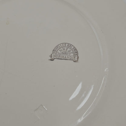 Marques minimes du temps (comme tout le monde !)
Sous l'assiette se trouve un tampon  :
en arc de cercle sur le haut : NOUVELLES GALERIES
Dessous : ENNEGÉ
et droit pour la base : NORMANDIE