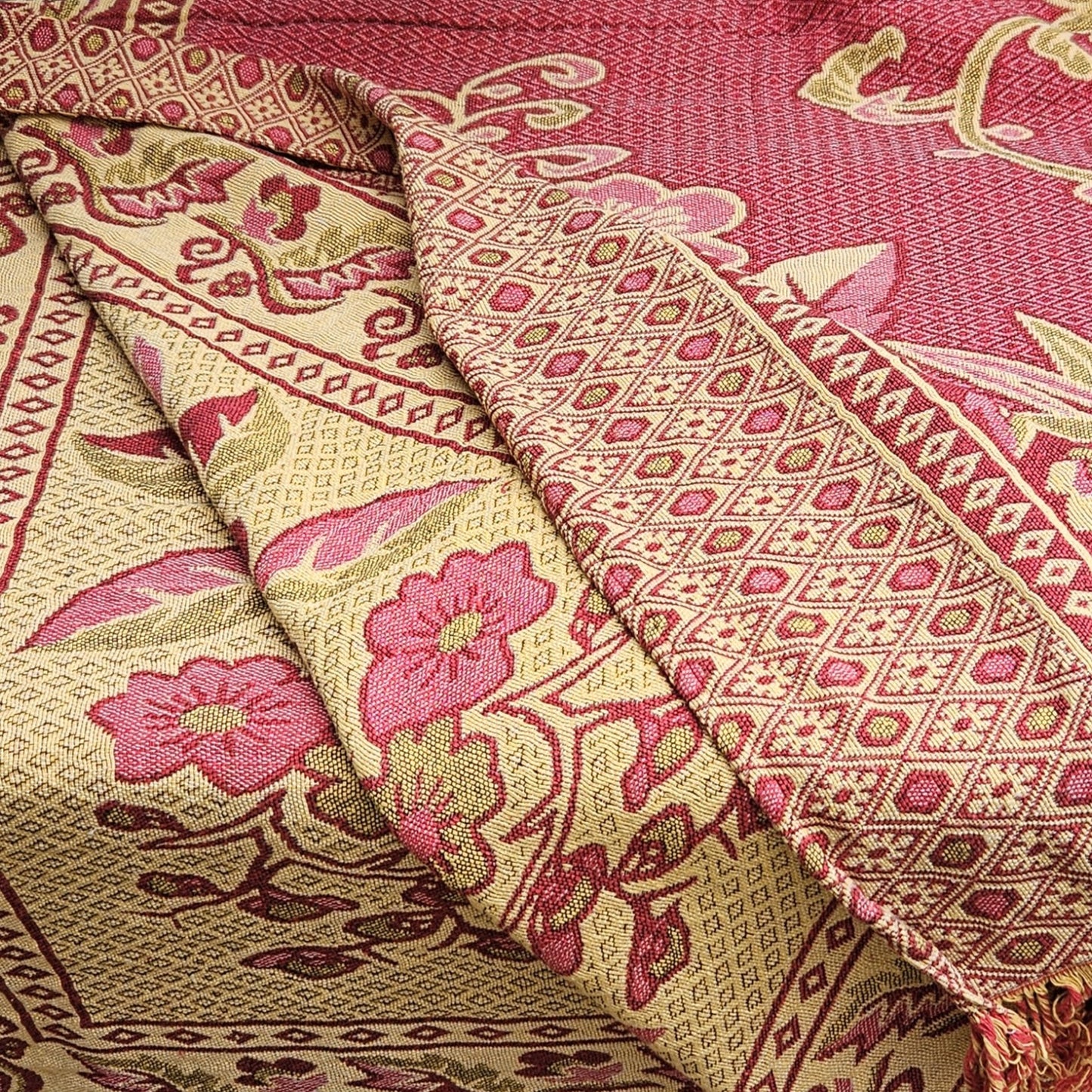 Détail rose/crème et de la double bordure à losanges géométriques et frise florale du jeté de lit en jacquard double face années 1950-1960, montrant les deux faces du tissu en repli.