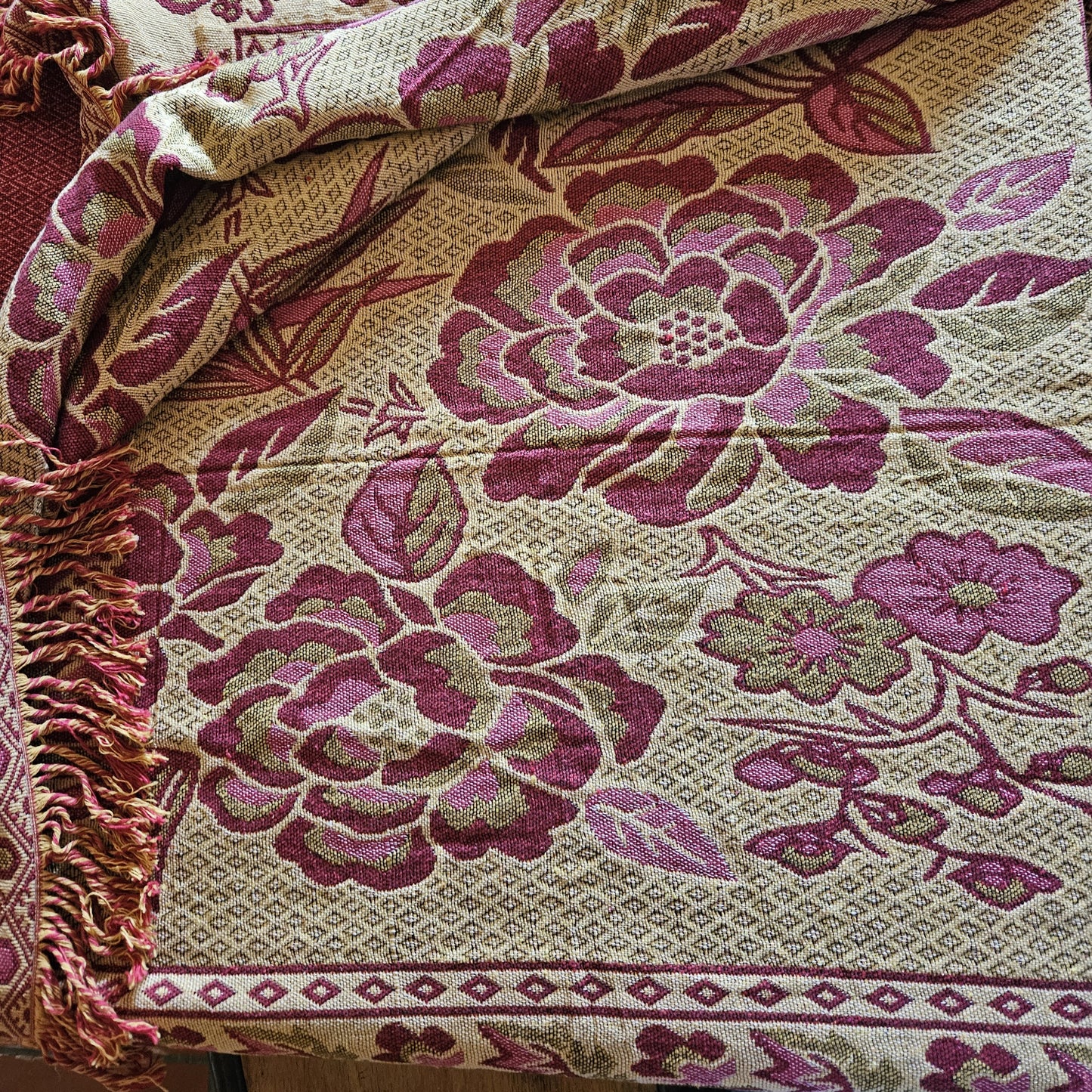 Détail des grandes fleurs en rose framboise sur fond crème/écru du jeté de lit en jacquard double face années 1950-1960, face envers, montrant la richesse du tissage jacquard et les franges torsadées rose/crème.