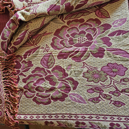 Détail des grandes fleurs en rose framboise sur fond crème/écru du jeté de lit en jacquard double face années 1950-1960, face envers, montrant la richesse du tissage jacquard et les franges torsadées rose/crème.