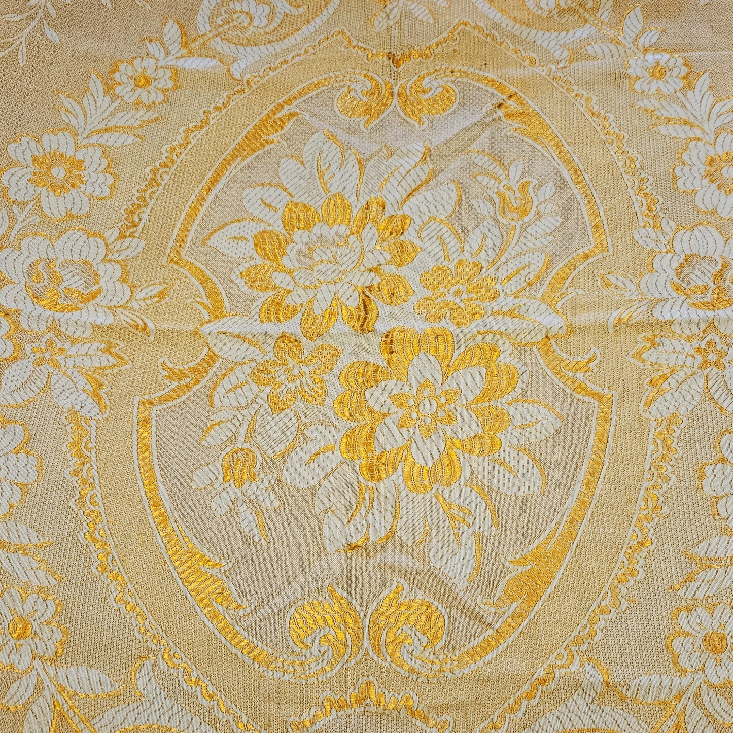 Détail du médaillon central en cartouche à écusson du jeté de canapé en jacquard double face années 1950-1960, face envers fond or/jaune intense, montrant le bouquet de pivoines et anémones en crème entouré de rinceaux et volutes Baroque, avec frise florale à roses en bordure.