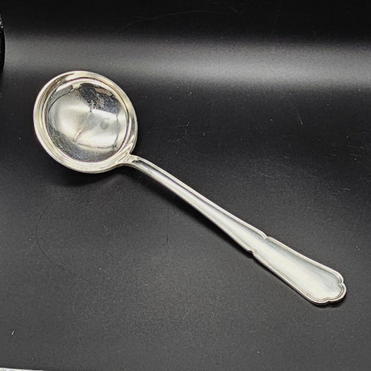 Louche à potage en métal argenté modèle Filet contour, 30,5 cm, vue de face sur fond noir, montrant la cuillère ronde et profonde et le long manche à double filet avec extrémité en trèfle.