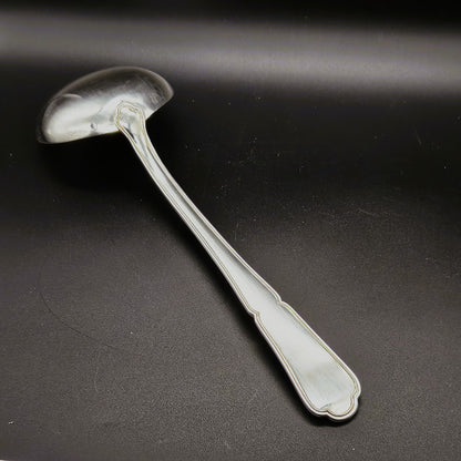 Louche à potage en métal argenté modèle Filet contour, 30,5 cm, vue de dos sur fond noir, montrant le dos de la cuillère ronde et le manche long légèrement incurvé à double filet.