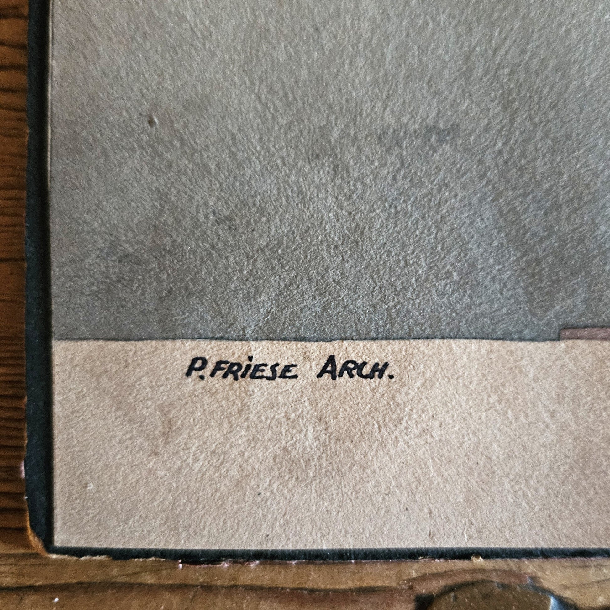 Gros plan sur la signature manuscrite « P. Friesé Arch. » inscrite en bas à gauche de l'aquarelle, sur le bord blanc du papier