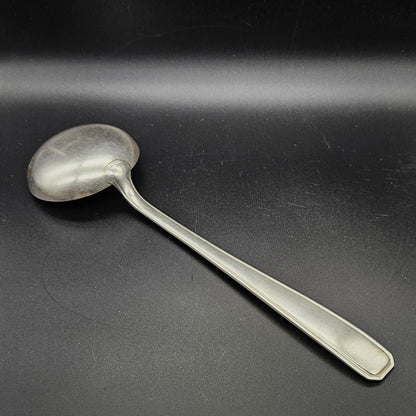 Louche à potage en métal argenté modèle de la Maison Boulenger Paris, 33,7 cm, vue de dos sur fond noir, montrant le dos de la cuillère ronde et le manche rectangulaire à filet périphérique unique avec extrémité à pans coupés octogonaux.